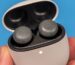 Google Pixel Buds Pro 2 in a charging case, in front of a blue background.